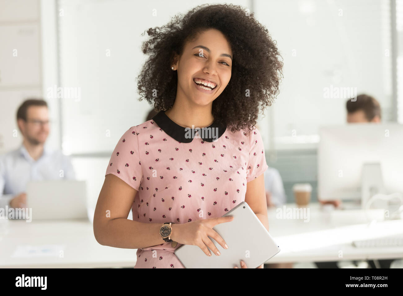 Gerne afrikanische Geschäftsfrau Holding digital Tablet an Kamera suchen Stockfoto