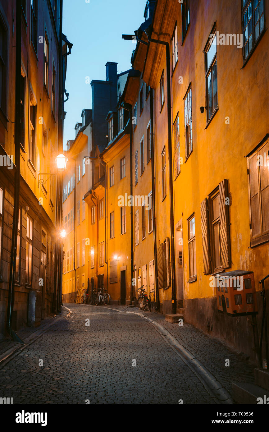 Klassische Dämmerung Blick auf traditionelle Häuser in der schönsten Gasse in der Stockholmer Altstadt Gamla Stan (Altstadt) während der Blauen Stunde in der Dämmerung beleuchtet, c Stockfoto