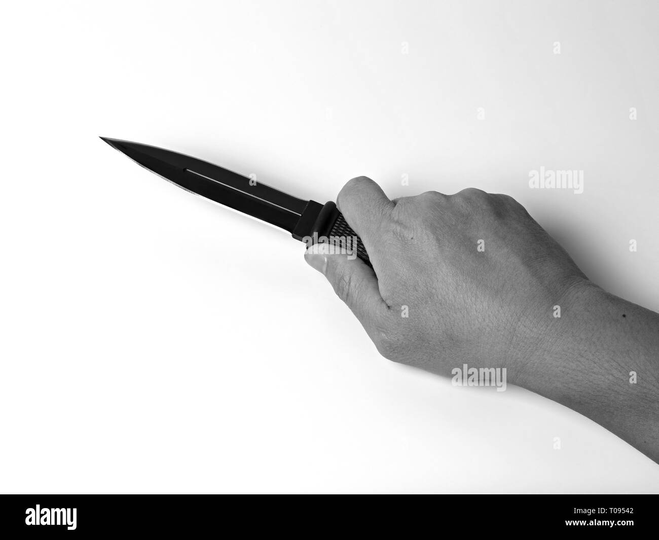 Closeup Hand mit einem Kampfmesser isoliert auf weißem Hintergrund, Schwarz und Weiß Stockfoto