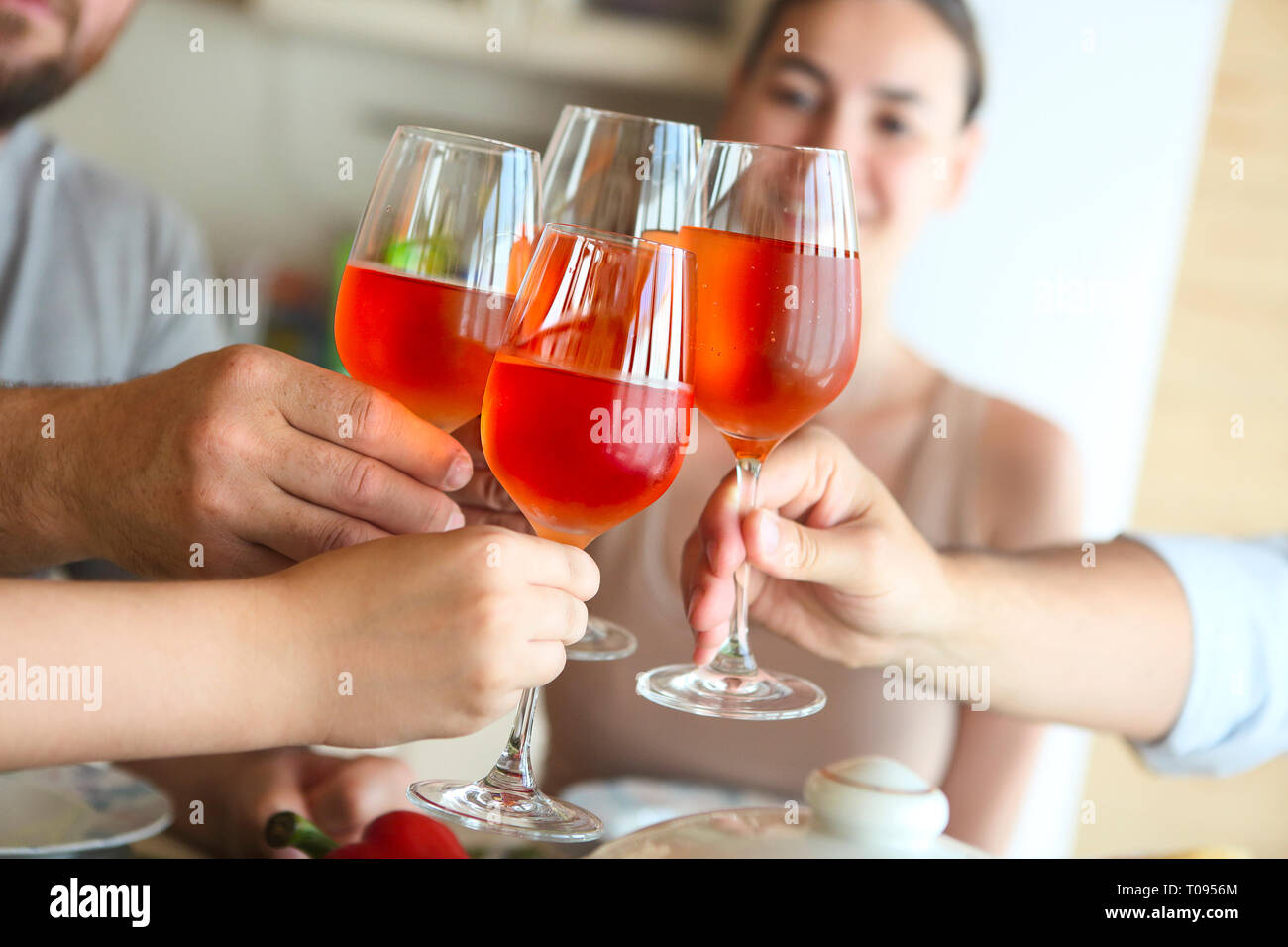 Nahaufnahme von vier Gläser mit Rose Wein zusammen klirrten bei einem Toast bei einer Feier, Stockfoto