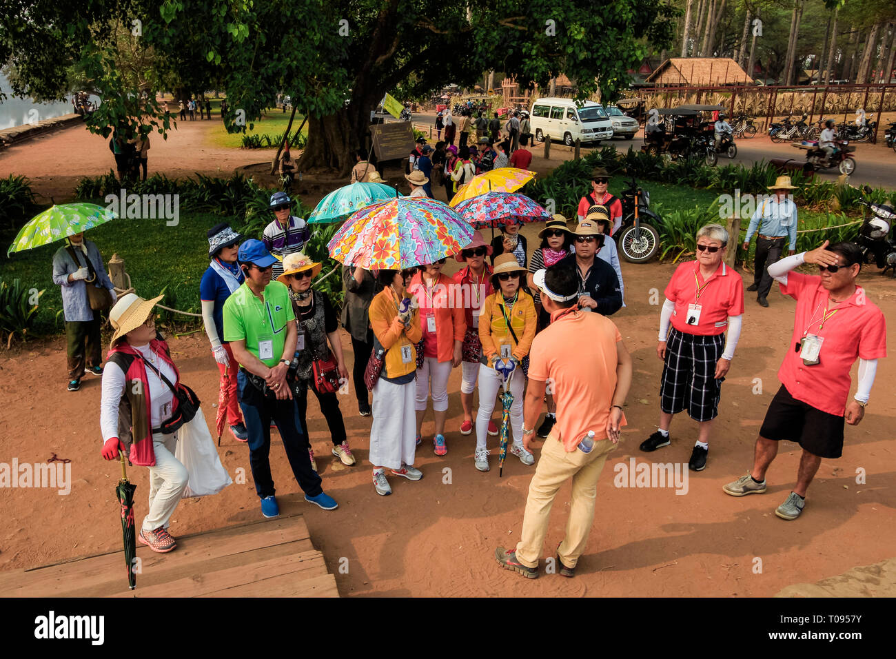 Osten asiatische Touristen montiert mit Führung am Haupteingang des berühmten 12 thC Tempel Angkor Wat, 7 Wunder der Welt. Angkor, Siem Reap, Kambodscha Stockfoto