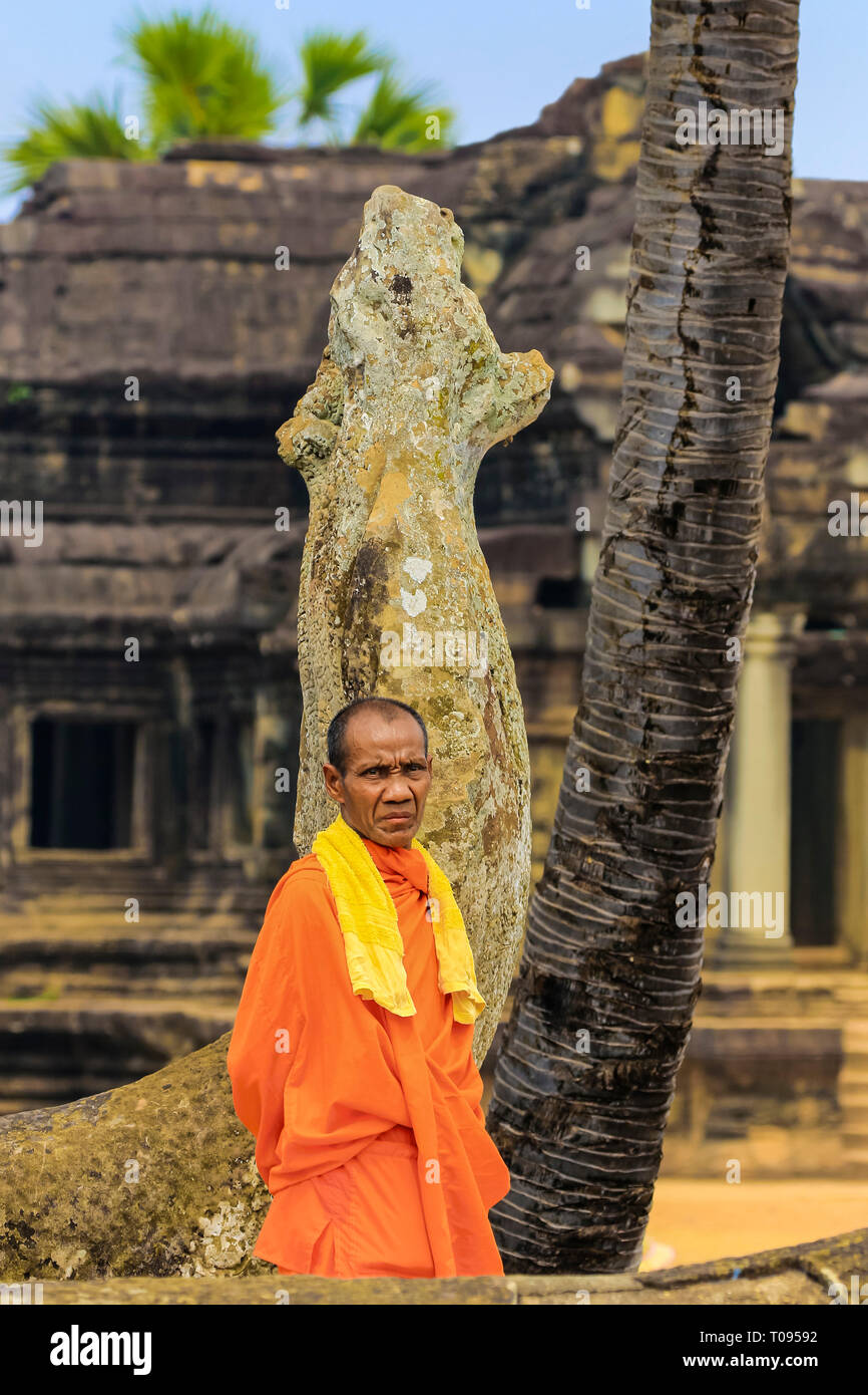 Buddhistischer Mönch in orange Robe von Naga Schlange statue am berühmten buddhistischen Tempelanlage Angkor Wat, Angkor, Siem Reap, Kambodscha. Stockfoto