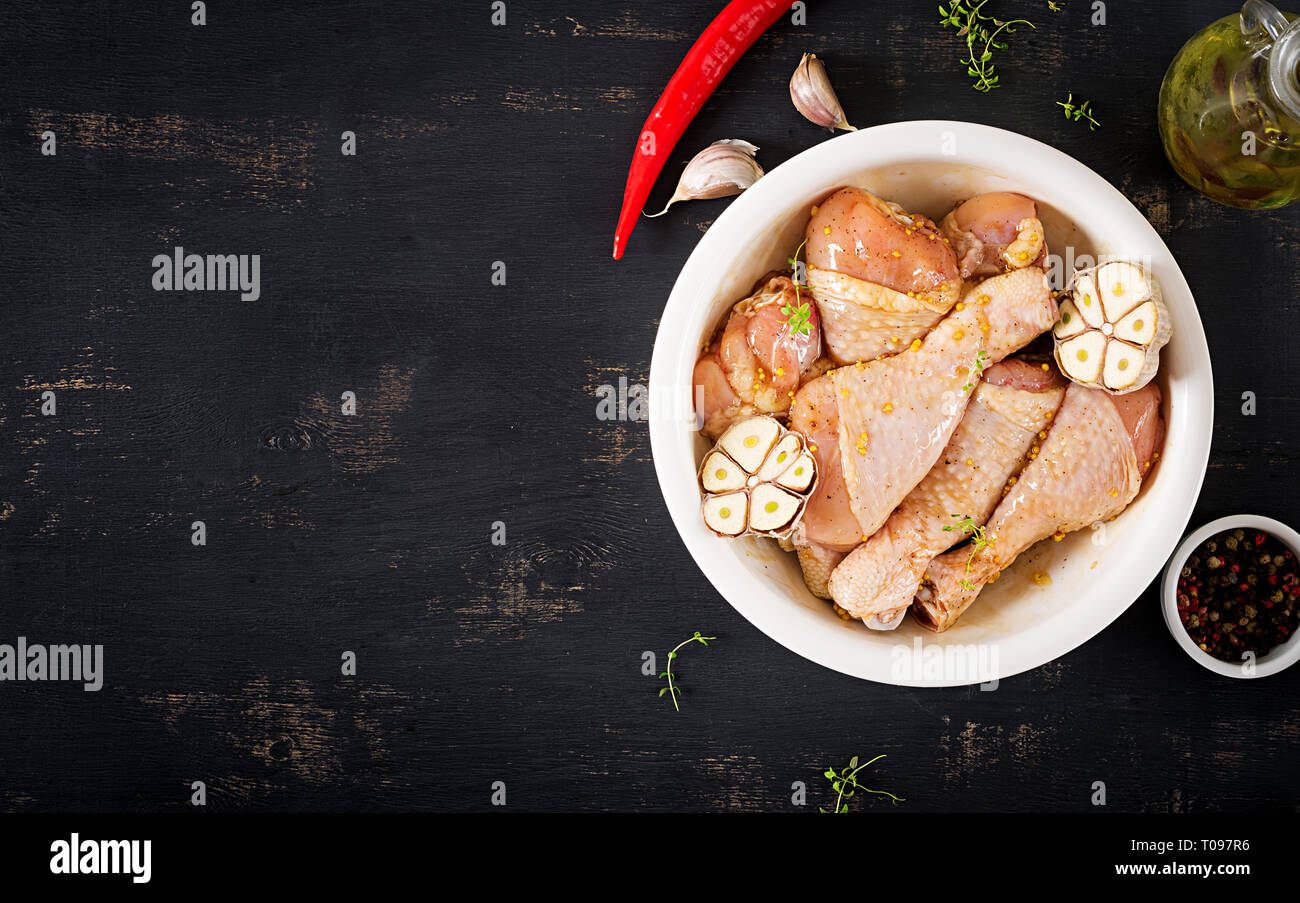 Roh roh marinierte Hähnchenschenkel, Drumsticks für das Kochen auf dunklen Tisch. Asiatische Küche. Ansicht von oben Stockfoto