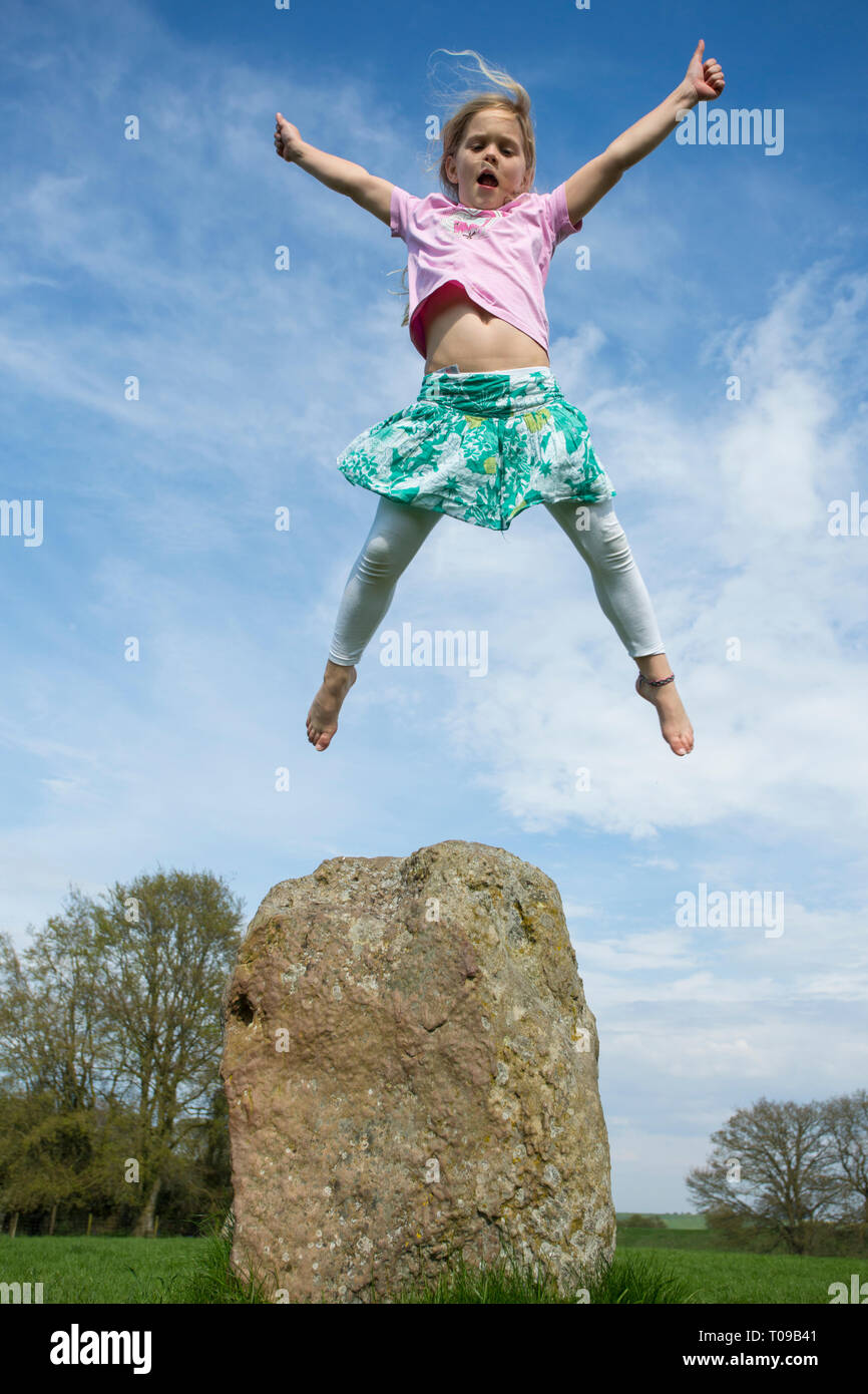 Großbritannien, Wiltshire, Avebury Stone Circle. Mädchen mit Power der Levitation über eine alte Stein Megalith. Mr. Stockfoto