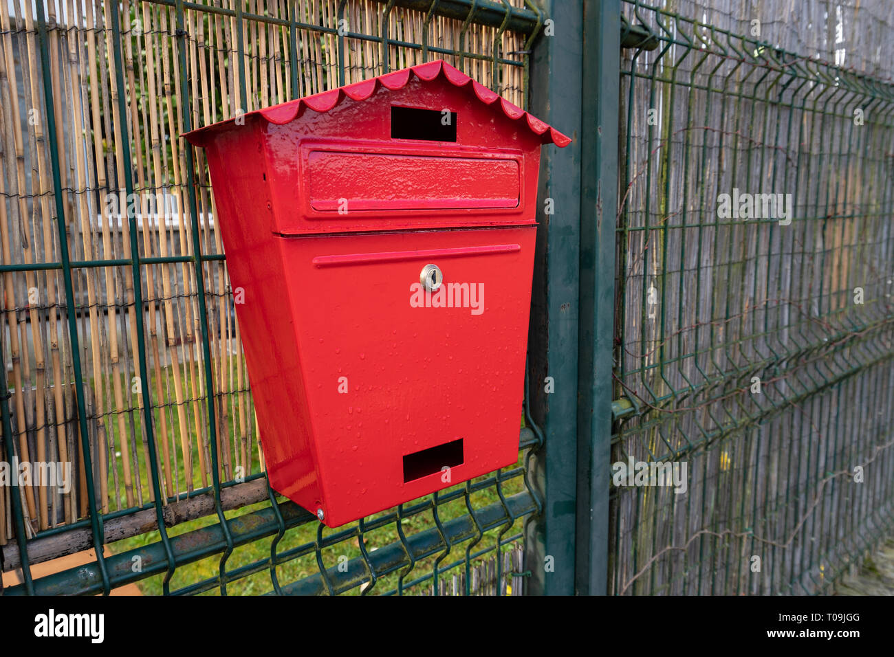 Red Mailbox auf metallischen Zaun. Im Freien Stockfoto