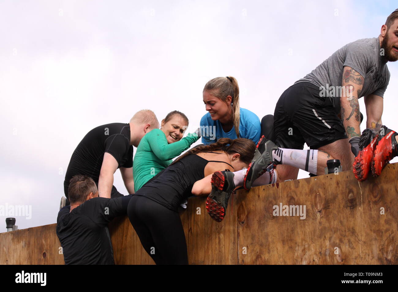 Aktive Menschen während extremer Hindernislauf in Boot Camp. Stockfoto