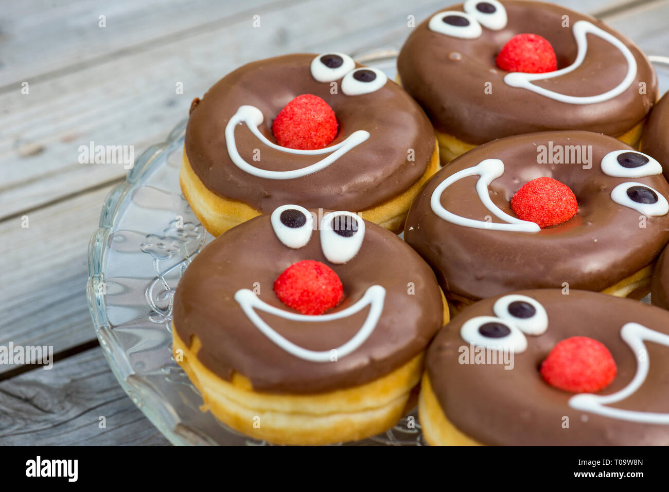 Schokolade glasierte Donuts mit lächelnden Gesichtern. geringe Schärfentiefe Stockfoto