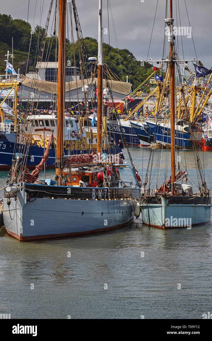 Restaurierte traditionelle Segeln Trawler, der mit der modernen Fischereiflotte in den Hintergrund, bis in den Hafen von Brixham, Devon, Großbritannien gebunden. Stockfoto