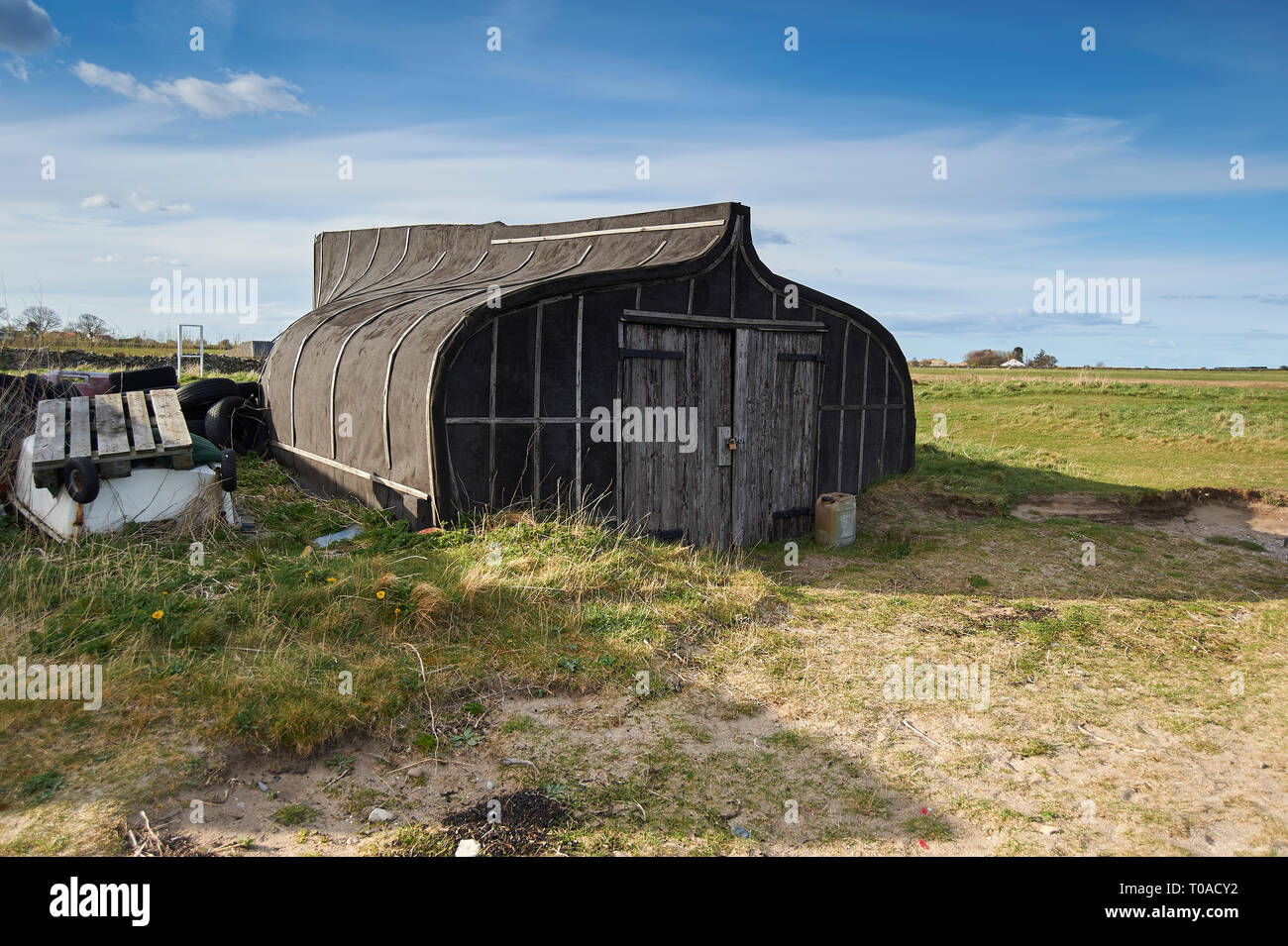 Umgedrehten Hering Boote verwendet als Lagerschuppen auf der Insel von Lindisfarne (Heilige Insel) auf der Northumbrian Küste im Norden von England, UK, GB. Stockfoto