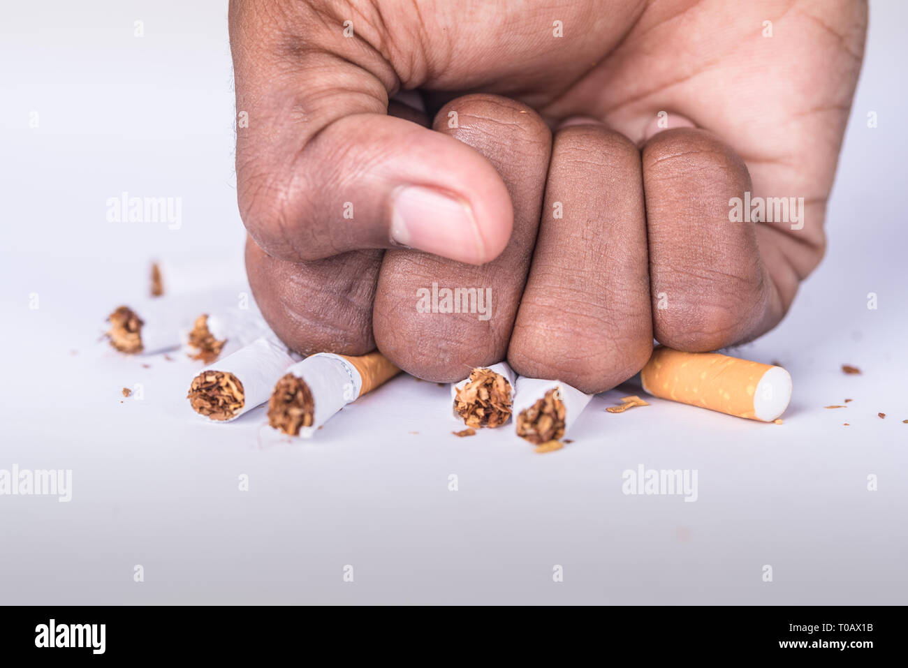 Ein Rauchverbot mit Hand Zerkleinern Zigarette auf weißem Tisch von Hand Stockfoto