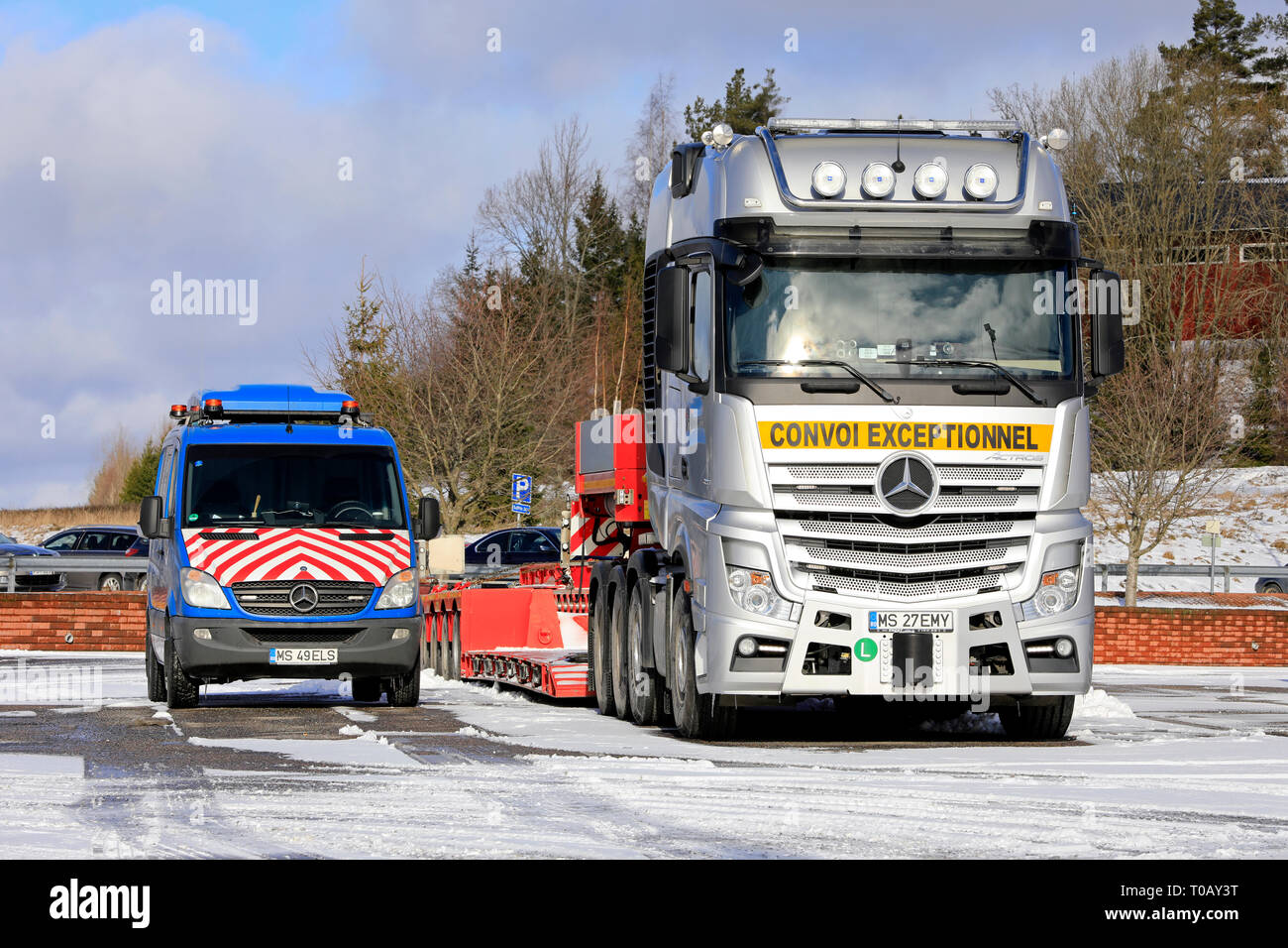 Salo, Finnland - 9. März, 2019: Mercedes-Benz Actros 4163 Semi Truck für Heavy duty Oversize load Transport und Pilot Fahrzeug auf Truck Stop geparkt. Stockfoto