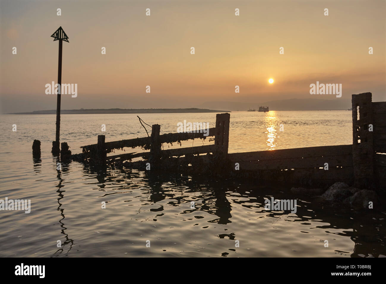 Eine Silhouette Shoreline groyne bei Sonnenuntergang gesehen, in der Mündung des Flusses Exe, Exmouth, Devon, Großbritannien. Stockfoto