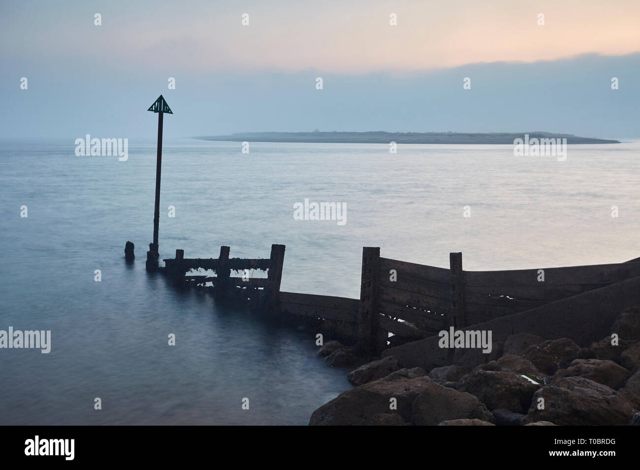 Eine Silhouette Shoreline groyne in der Abenddämmerung gesehen, in der Mündung des Flusses Exe, Exmouth, Devon, Großbritannien. Stockfoto