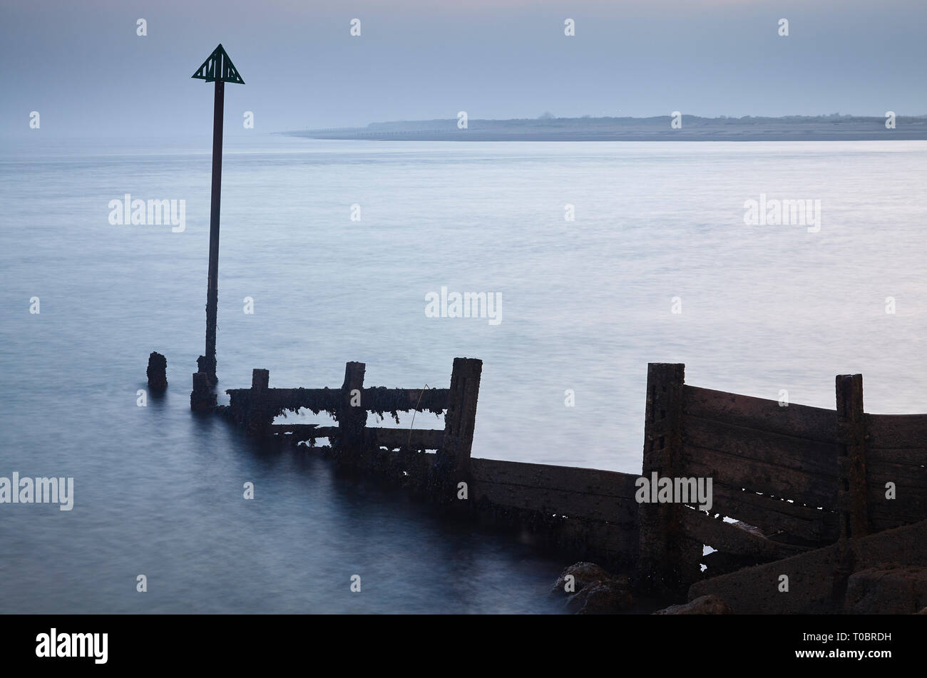 Eine Silhouette Shoreline groyne in der Abenddämmerung gesehen, in der Mündung des Flusses Exe, Exmouth, Devon, Großbritannien. Stockfoto