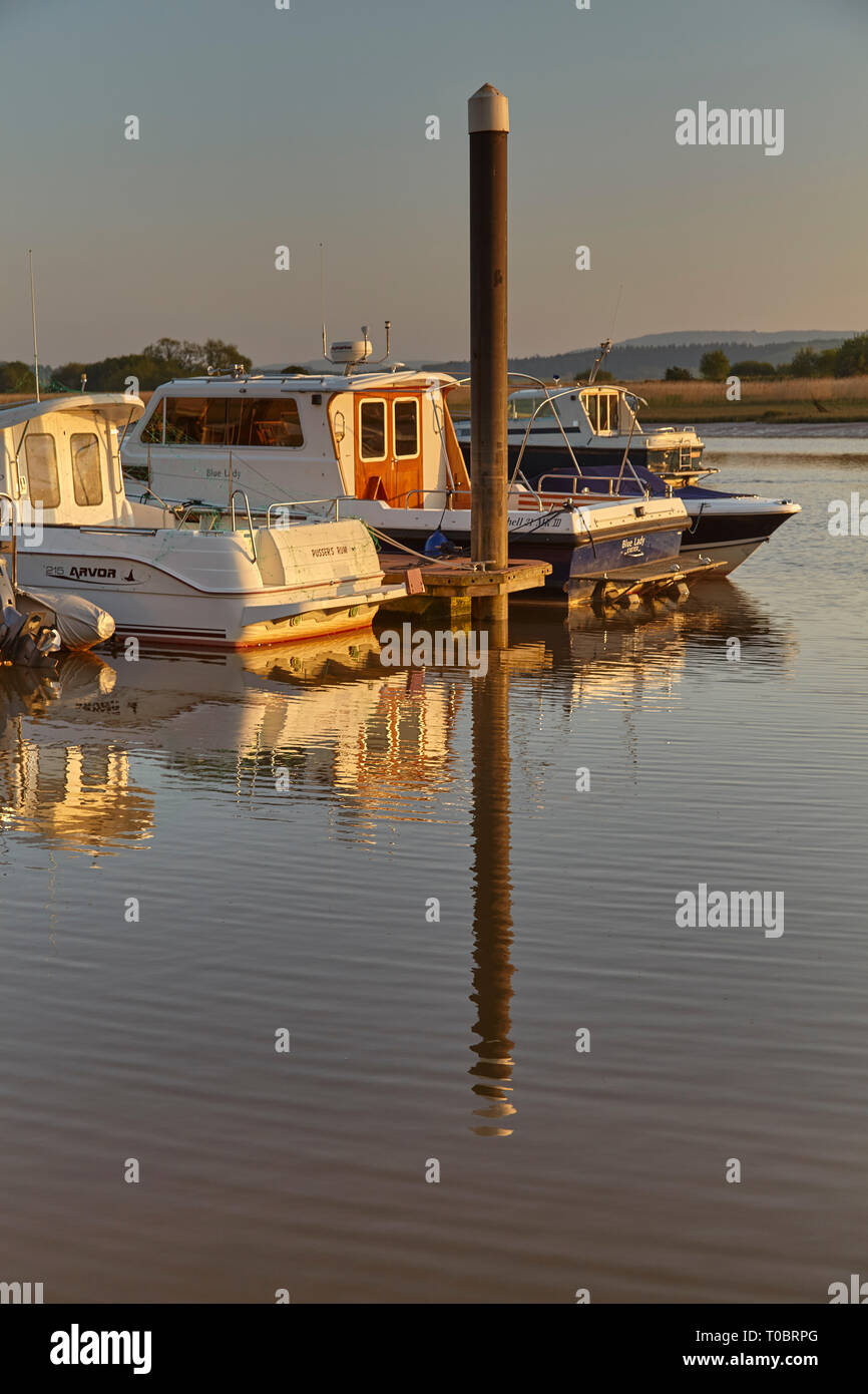 Angelegte Boote in der Abendsonne, an Pontons im Hafen von Brunswick, an der Mündung des Flusses Exe, in der Nähe von Exeter, Devon, Großbritannien. Stockfoto