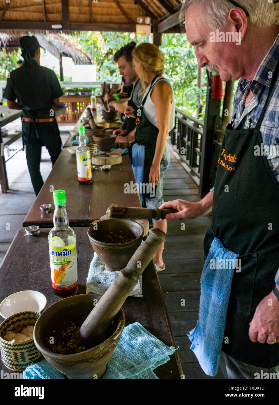 Touristen in SE asiatischen Lao Kochkurs mit Stößel und Mörser und Fischsauce, Tamarind Kochschule, Luang Prabang, Laos Stockfoto