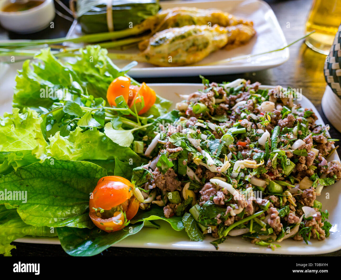 SE asiatischen Lao Gericht mit Rindfleisch laap oder Salat und gefüllte Zitronengras im Tamarind Kochschule, Luang Prabang, Laos Stockfoto