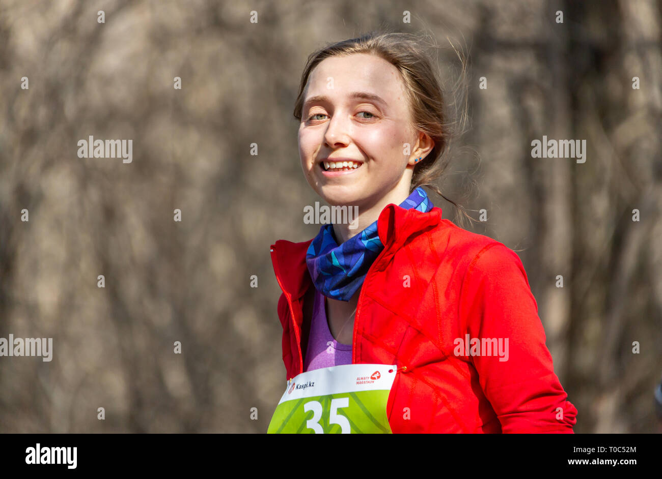 ALMATY, Kasachstan - 16. März 2019: Eine schöne junge unbekannte Mädchen läuft durch den Wald im Frühling Marathon in der Stadt Almaty, in einem Stockfoto
