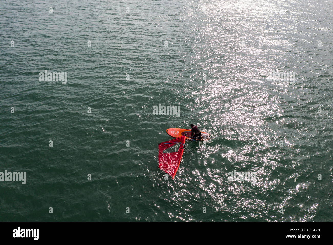 Eine Antenne Bild eines Wind surfer bis zu seinem Surfbrett auf Singapore Straits Wasser. Stockfoto