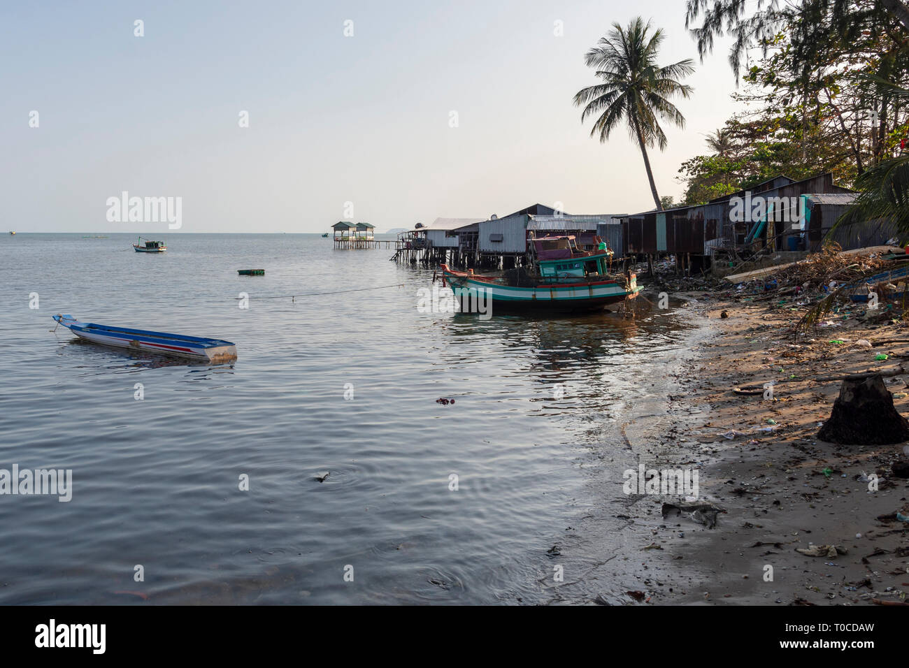 Fischerboote und einfache Bootshaus und eine Menge der Verschmutzung die Häuser am Strand, Bild rom Schinken Ninh auf der Insel Phu Quoc, Vietnam. Stockfoto