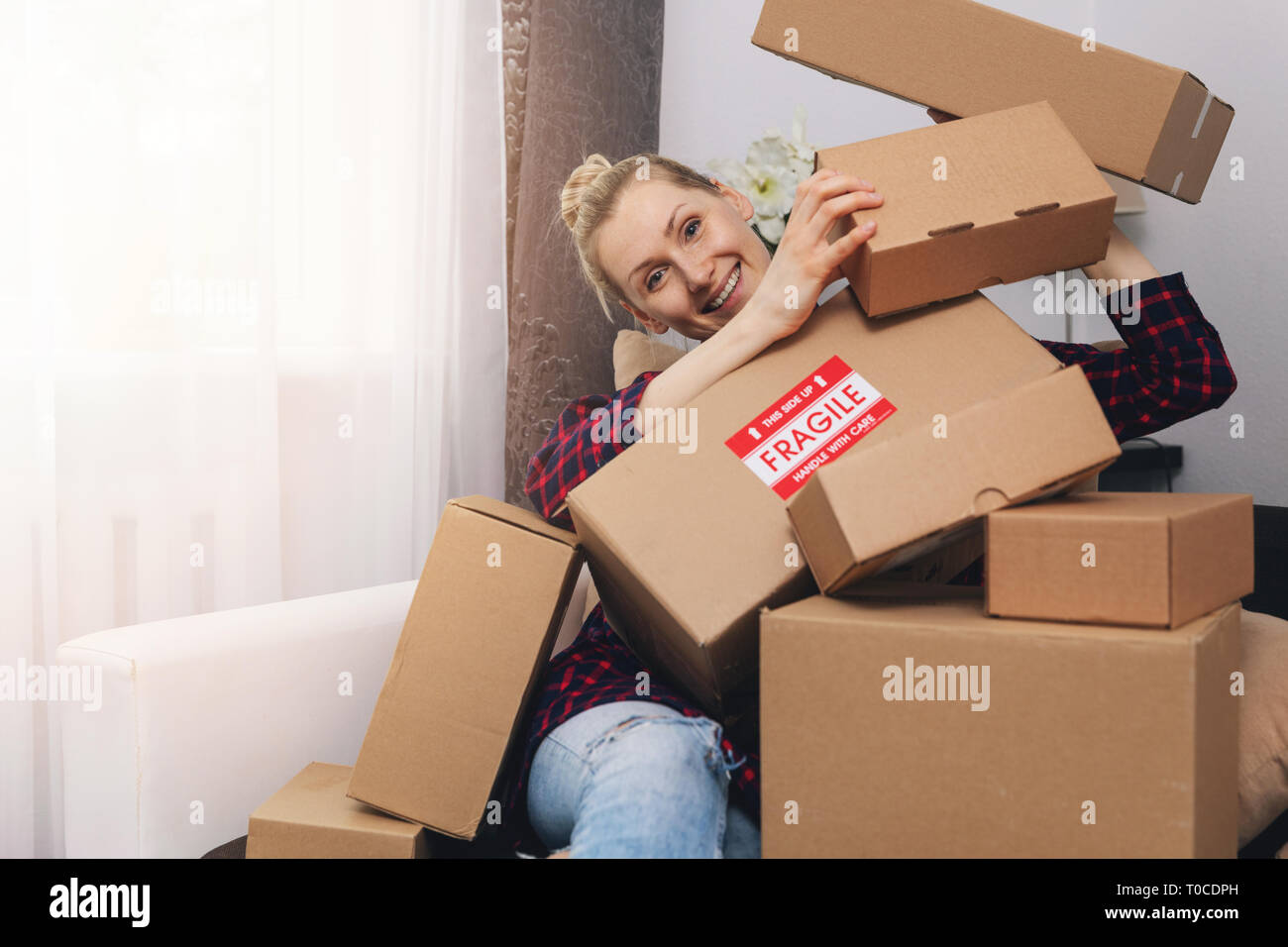 Konsumismus Konzept - glückliche Frau mit Kartons zu Hause nach dem Einkaufen Stockfoto