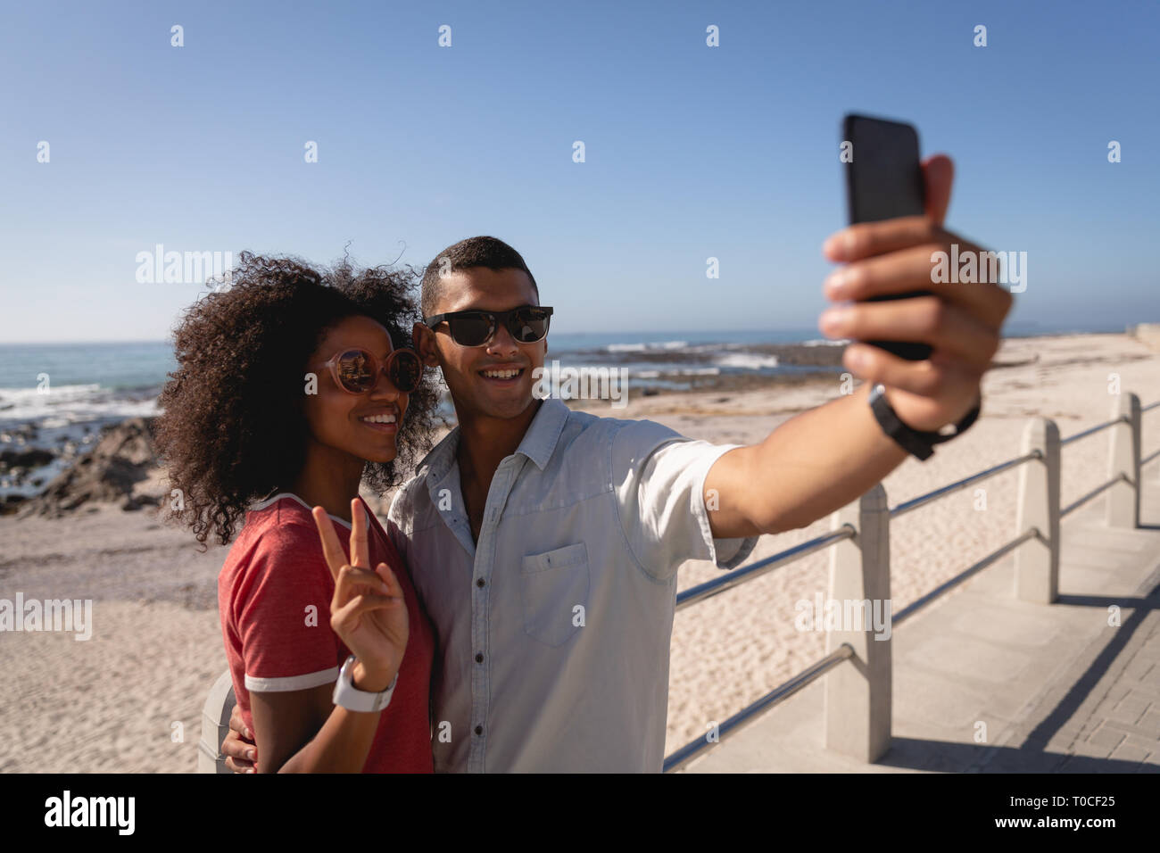 Paar stehen und sprechen selfie am Strand Stockfoto