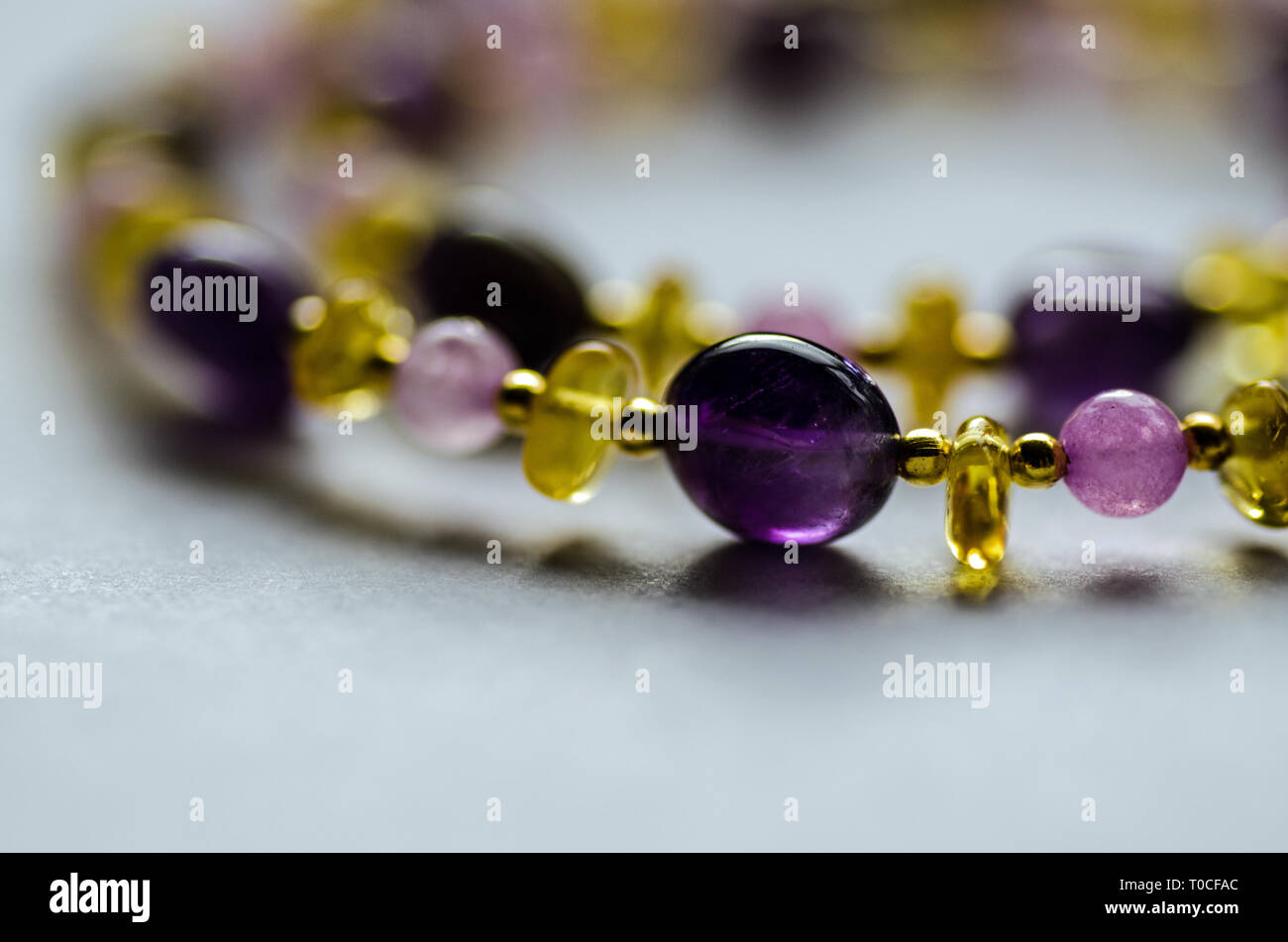 Kette aus Amethyst, Quarz und Amber beads mit vergoldeten Perlen durchsetzt. Stockfoto