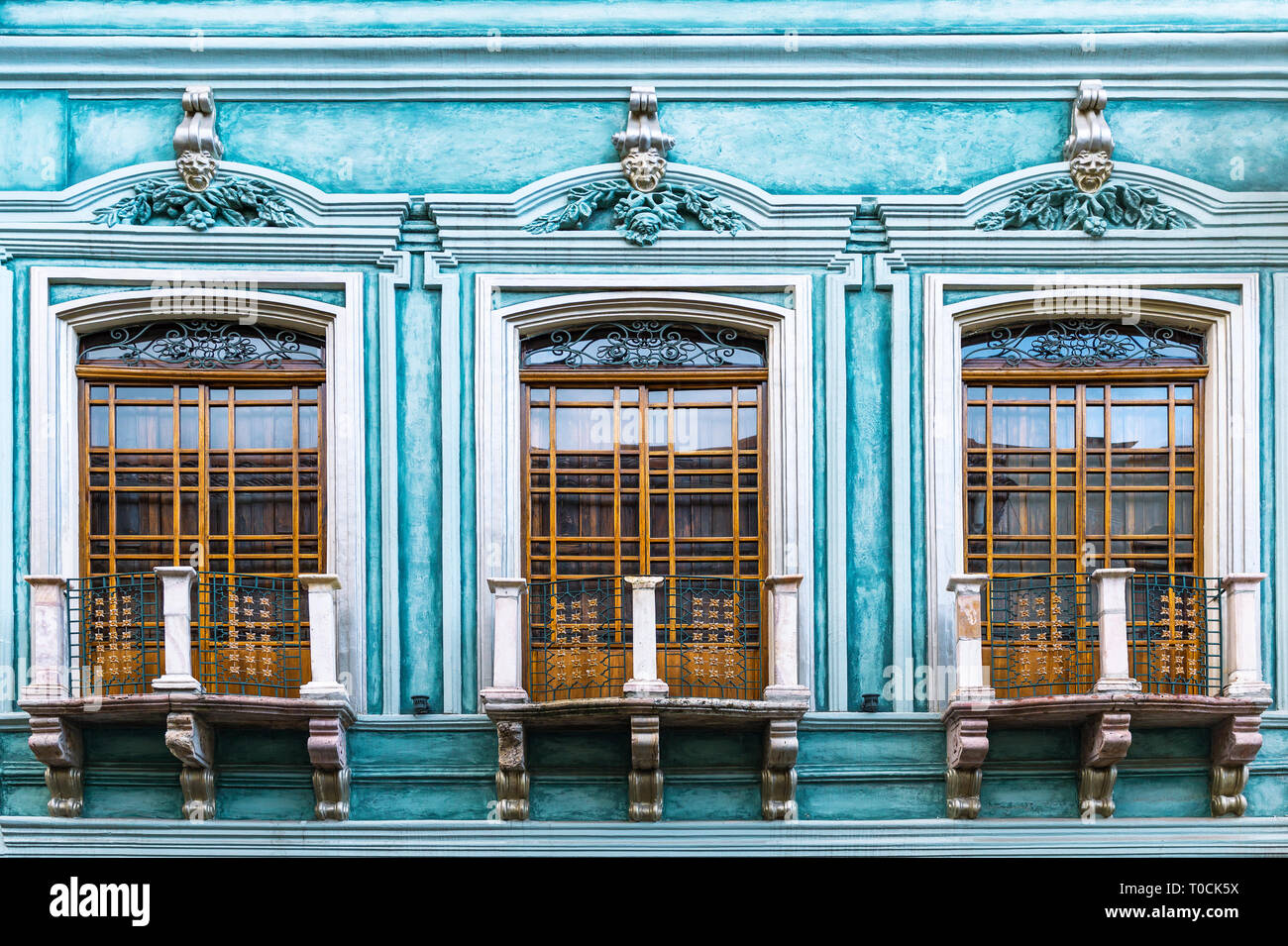 Die Komplexität einer Türkis Kolonialstil Fassade mit Balkon in der Altstadt von Cuenca, Ecuador, Südamerika. Stockfoto