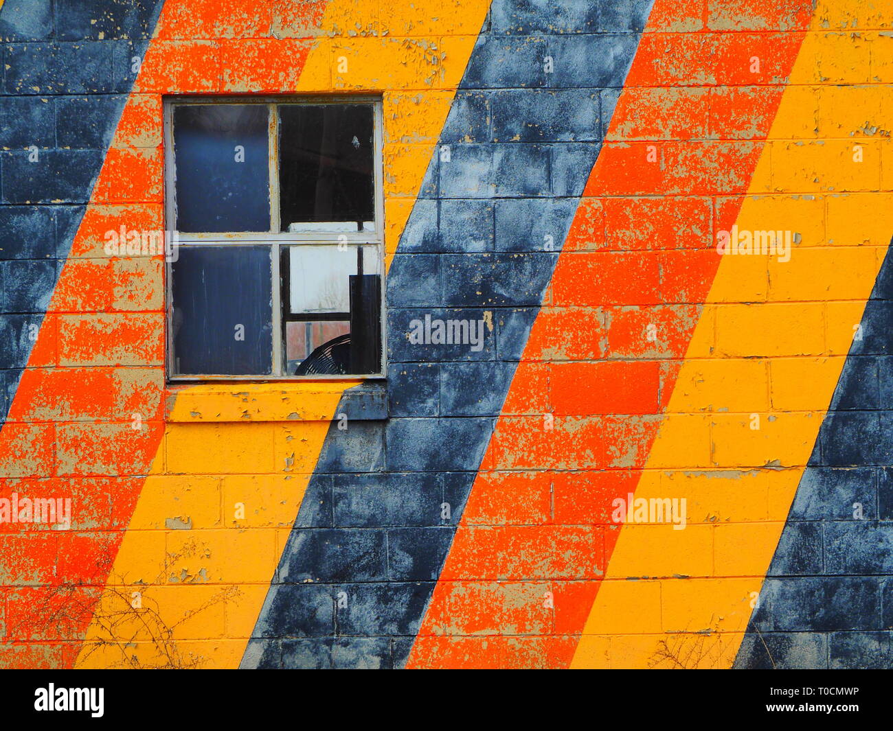 Schwarz gelb und orange Streifen auf Gebäude mit einem Fenster schließen nach oben Stockfoto