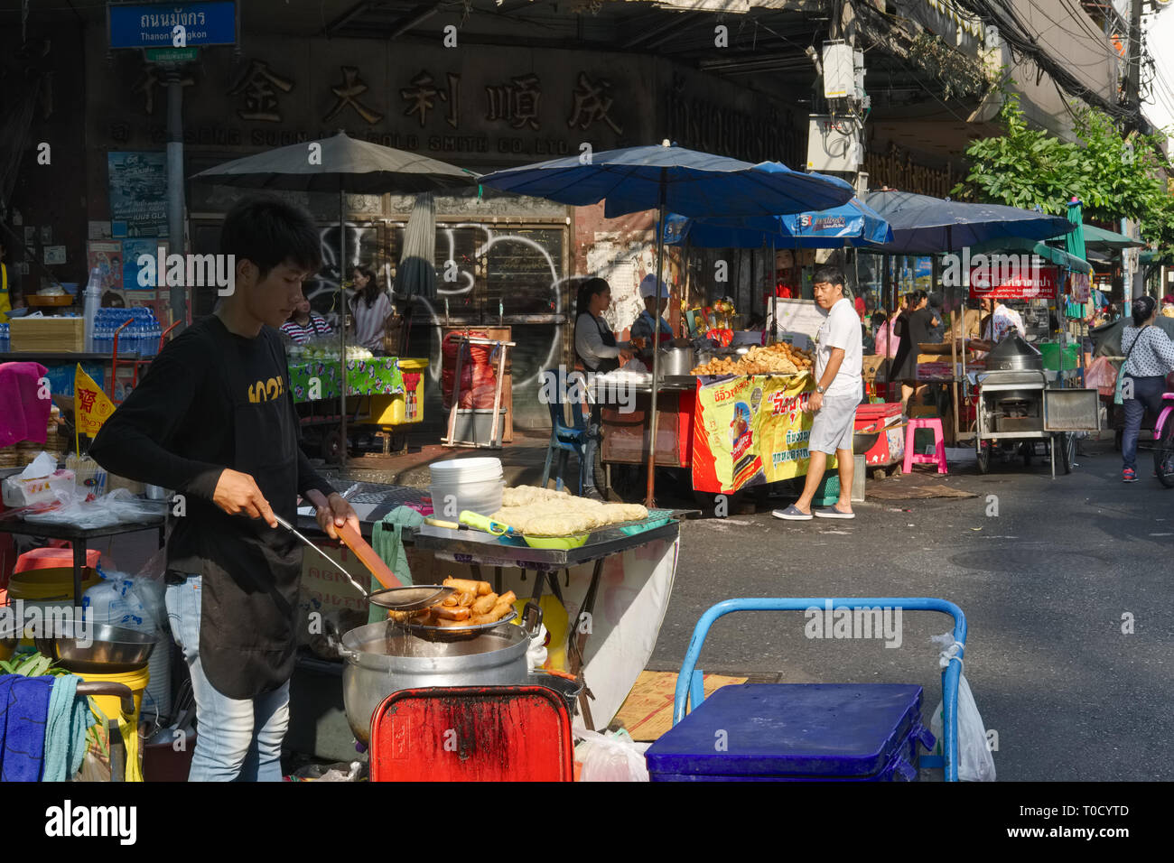 Ein Straßenhändler in Chinatown, Bangkok, Vorbereitung frittierte Frühlingsrollen Stockfoto