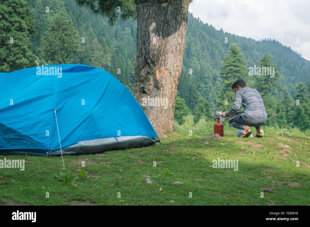 Eine Person Einschalten der Gas Food in der Nähe seiner camping Zelt auf einem Campingplatz in Pahalgam in Kaschmir zu kochen Stockfoto