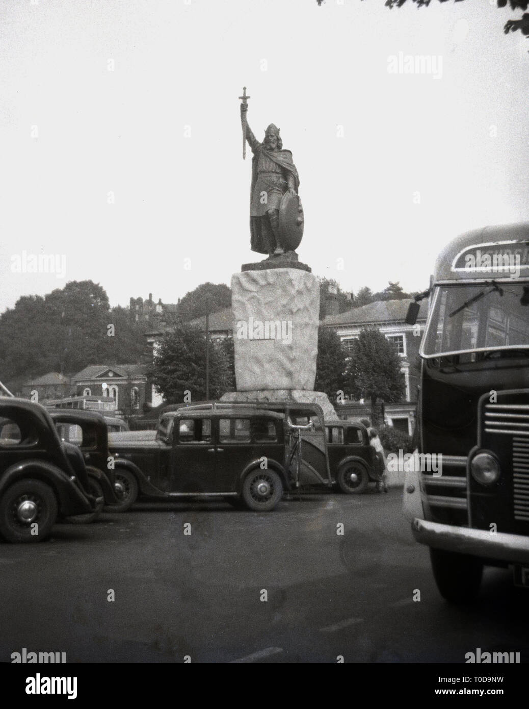 1940, Autos der Epoche um die Statue von Alfred dem Großen, dem sächsischen König, in Winchester, Hampshire, England, UK geparkt. Stockfoto