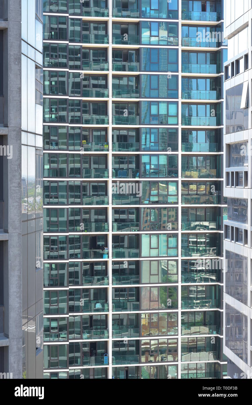 Glas Außenwand von hohes Apartmentgebäude mit Zeilen und Spalten von Balkonen und Fenstern. Stockfoto