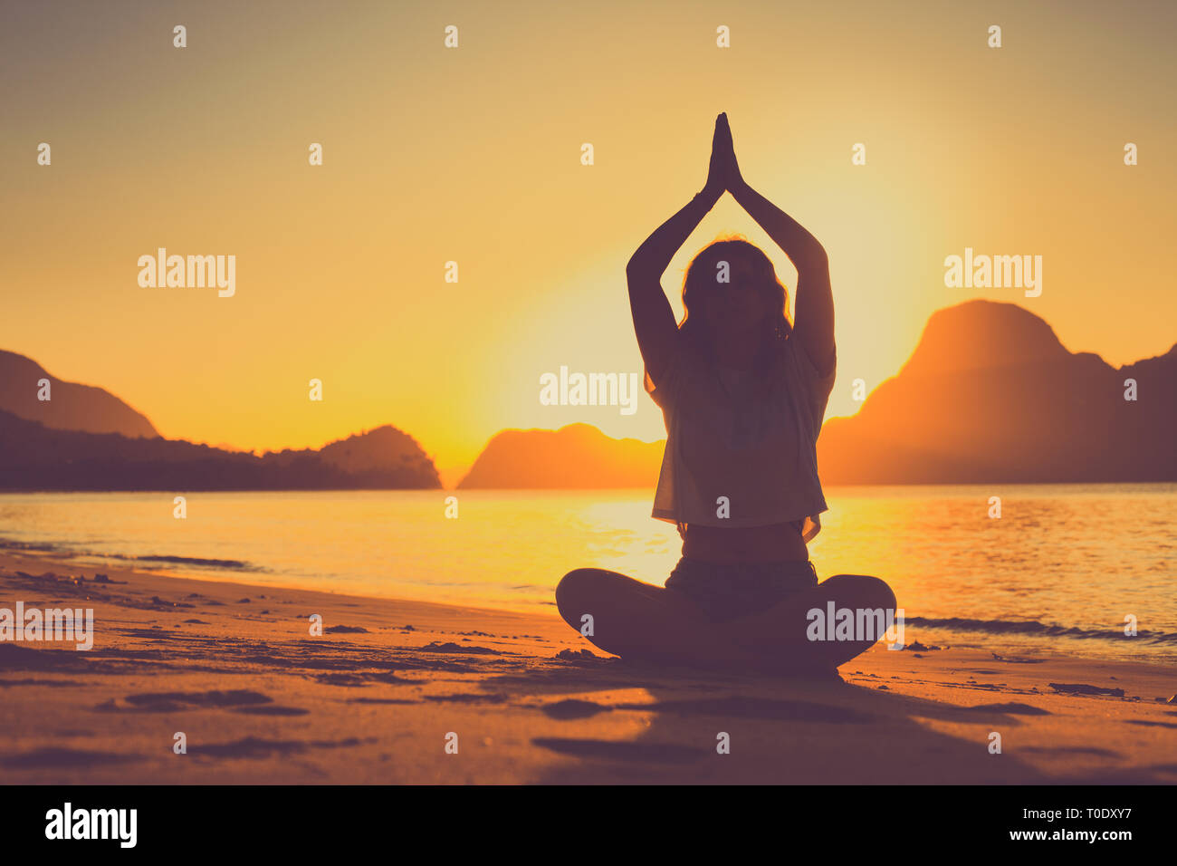 Meditation Frau am Meer mit Felsen Stockfoto