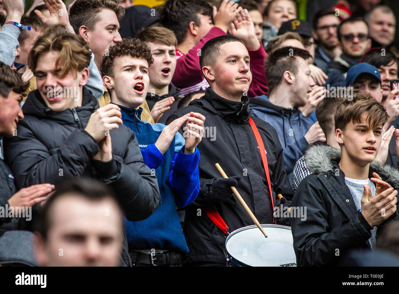 Englische Fußball-Club Fans und Unterstützer beobachten und spielen Drum Stockfoto