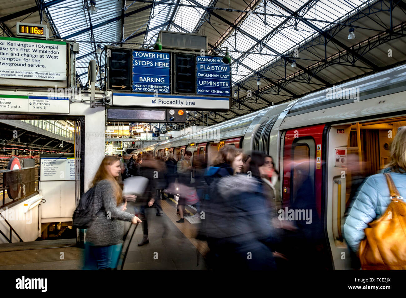 Am Bahnhof Earl's Court im Südwesten Londons, London, Großbritannien, steigen Passagiere vom Bahnsteig in einen U-Bahn-Zug der District Line ein Stockfoto