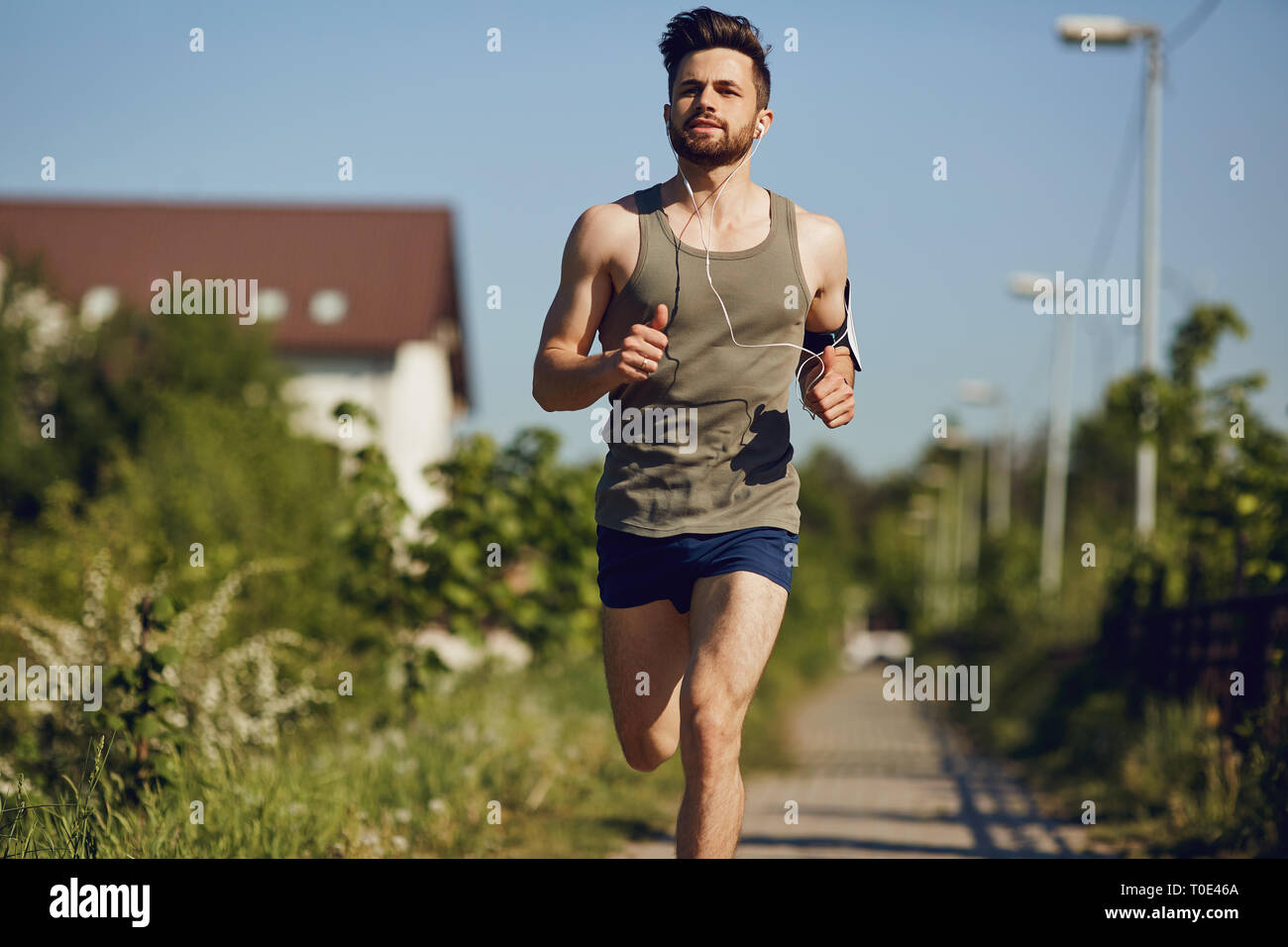 Eine männliche Läufer läuft entlang der Straße zum Park. Stockfoto