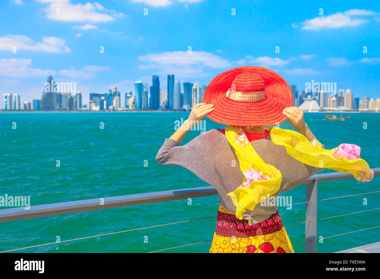 Katar Travel Concept. Elegante kaukasische Frau Untersuchungsarbeit der Blick auf Doha West Bay. Blond Tourist in Doha in der Innenstadt von Osten Mound-Skyline Sicht Stockfoto