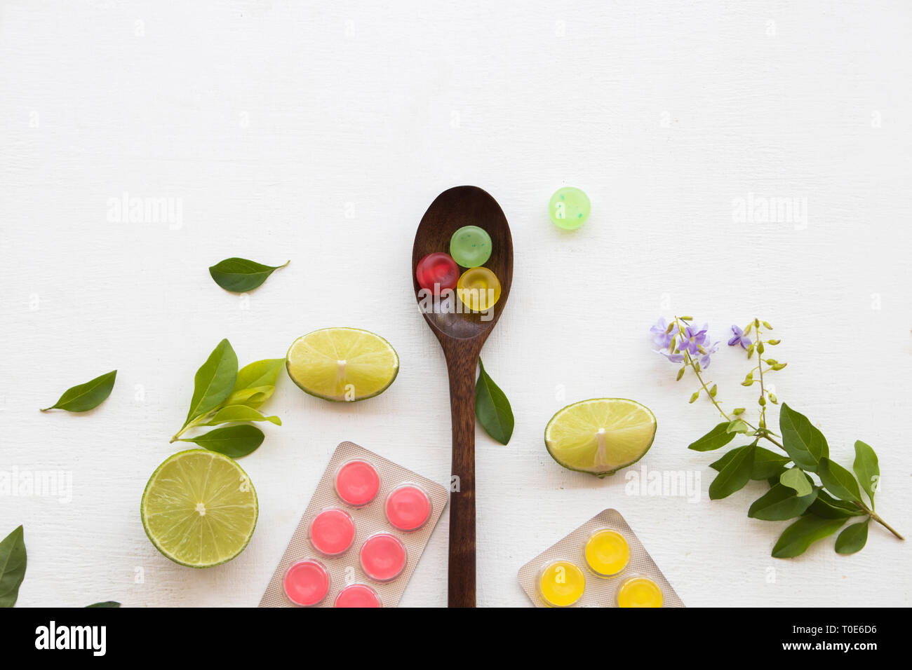 Bunte lozenge und Zitronenscheibe Gesundheit Halsschmerzen mit lila Blumen Dekoration flach Stil auf Hintergrund weiss Stockfoto