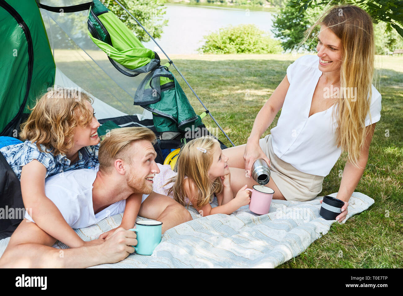 Glückliche Familie mit zwei Kindern vor dem Zelt auf dem Campingplatz Urlaub im Sommer Stockfoto