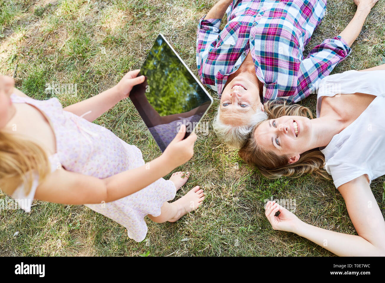 Mädchen mit Tablet Computer Fotos Mutter und Großmutter im Garten Stockfoto