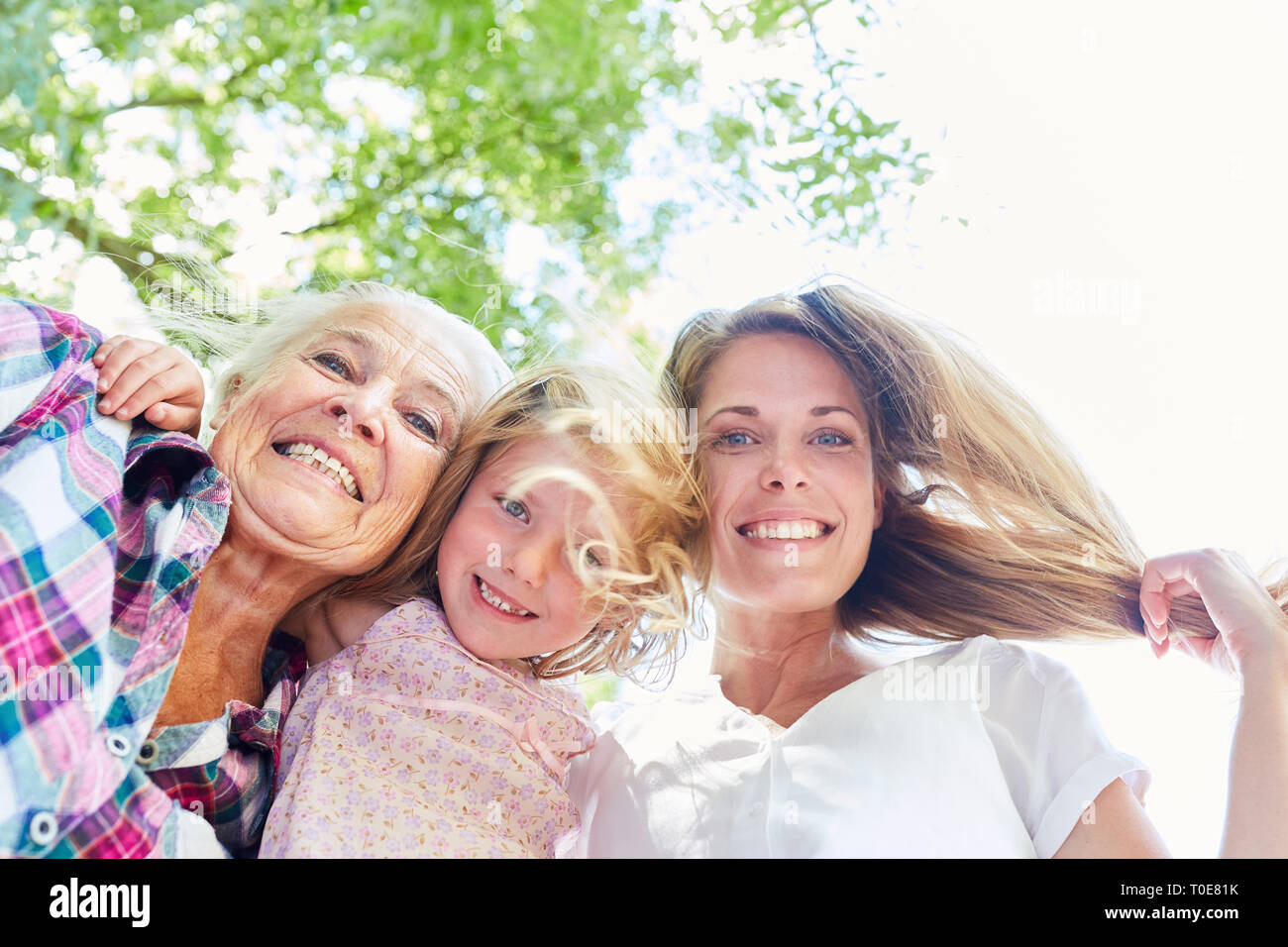 Drei fröhlichen Frauen in drei Generationen als eine erweiterte Familie im Sommer in den Garten Stockfoto