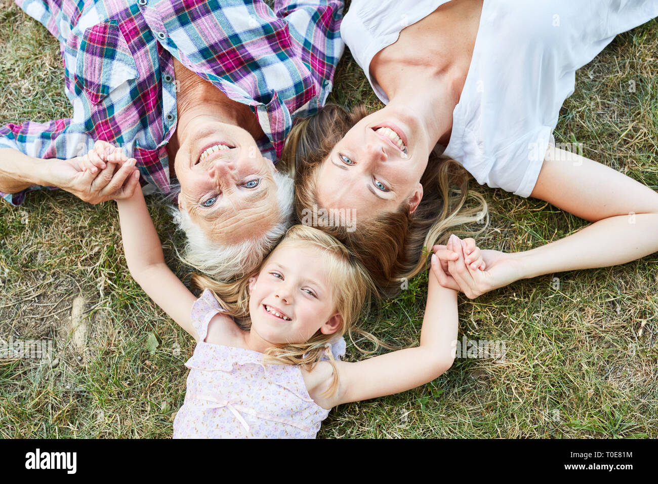 Kleines Mädchen auf einer Wiese zusammen mit ihrer Mutter und ihrer Großmutter Stockfoto