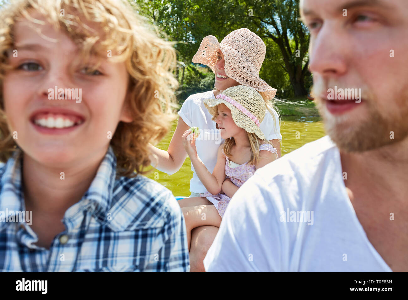Familie mit zwei Kindern macht Outing im Ruderboot auf einem See im Sommer Stockfoto