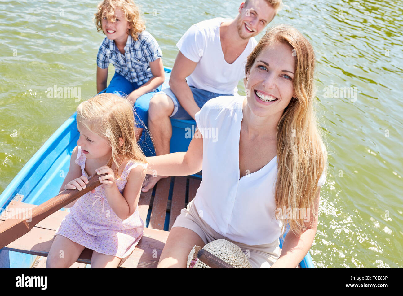 Glückliche Familie mit zwei Kindern eine Bootstour im Ruderboot im Sommer Stockfoto