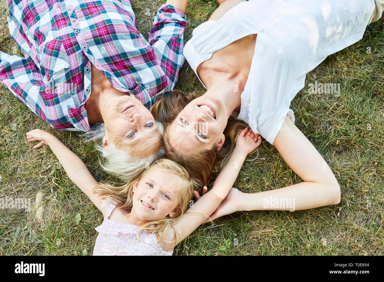Happy girl als Enkelin zusammen mit Mutter und Großmutter auf einer Wiese Stockfoto