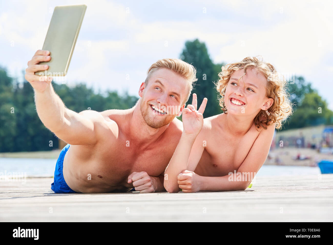 Vater und Sohn mit Tablet-PC eine selfie am Meer im Sommer Urlaub machen Stockfoto