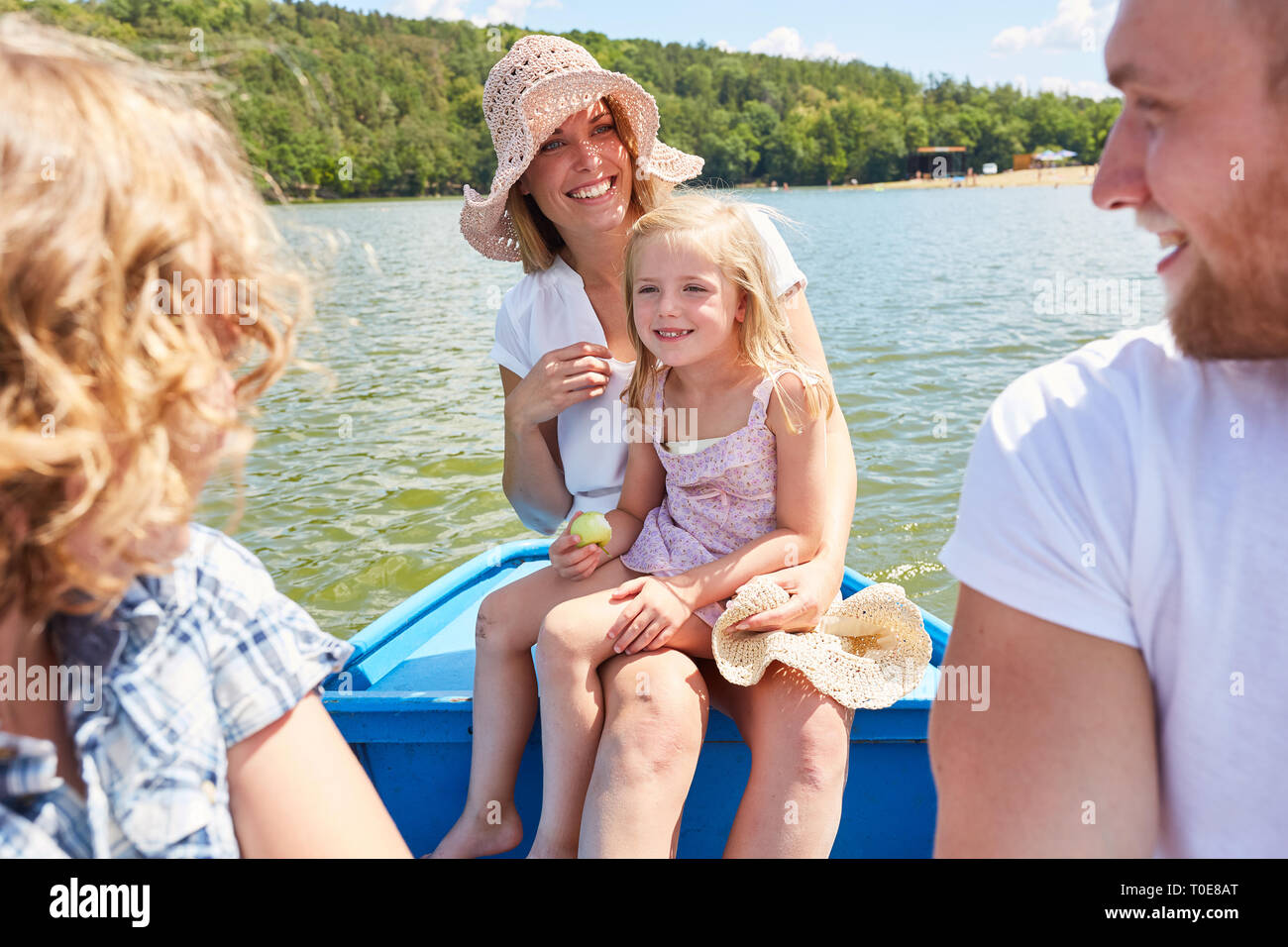 Familie mit zwei Kindern im Sommerurlaub ist eine Bootsfahrt auf dem See Stockfoto