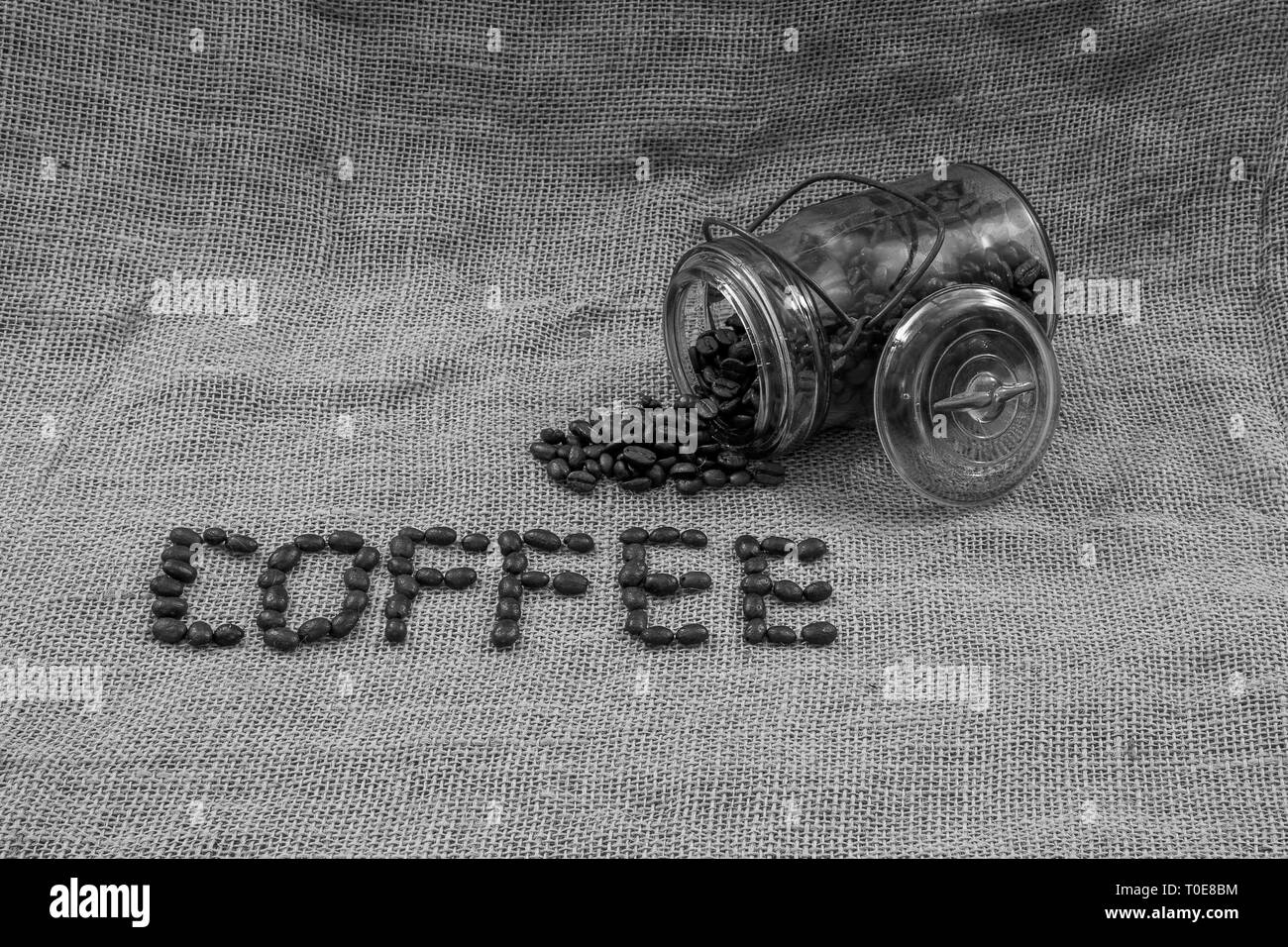 Kaffee Bohnen, Kaffee und ein antikes Glas mit Bohnen, verschüttet Stockfoto