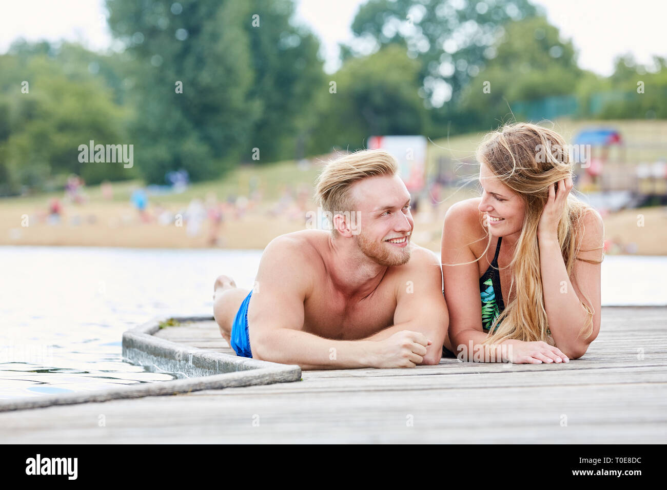 Junges Paar in Liebe flirten auf einem Pier am Meer auf Urlaub im Sommer Stockfoto